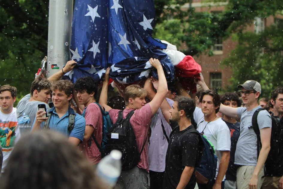 A dozen members of the Jewish fraternity AEPi were among the young men who held the American flag aloft after anti-Israel protesters tore it down.
Credit: Parker Ali/Daily Tar Heel